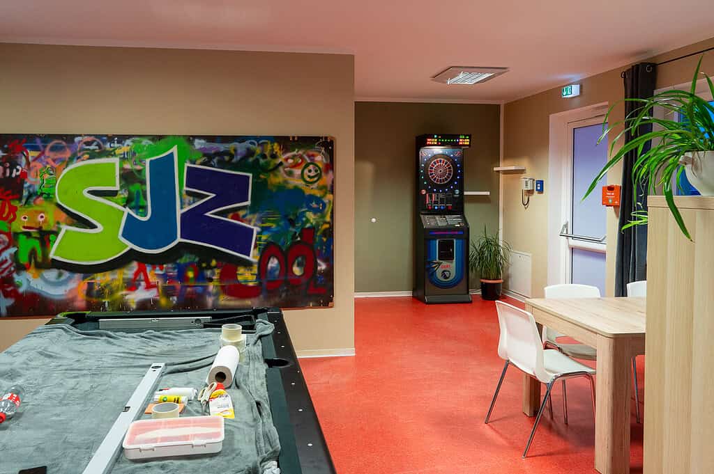 Modernes Jugendzentrum Zingst mit Billardtisch, Dartautomat und Sitzbereich.