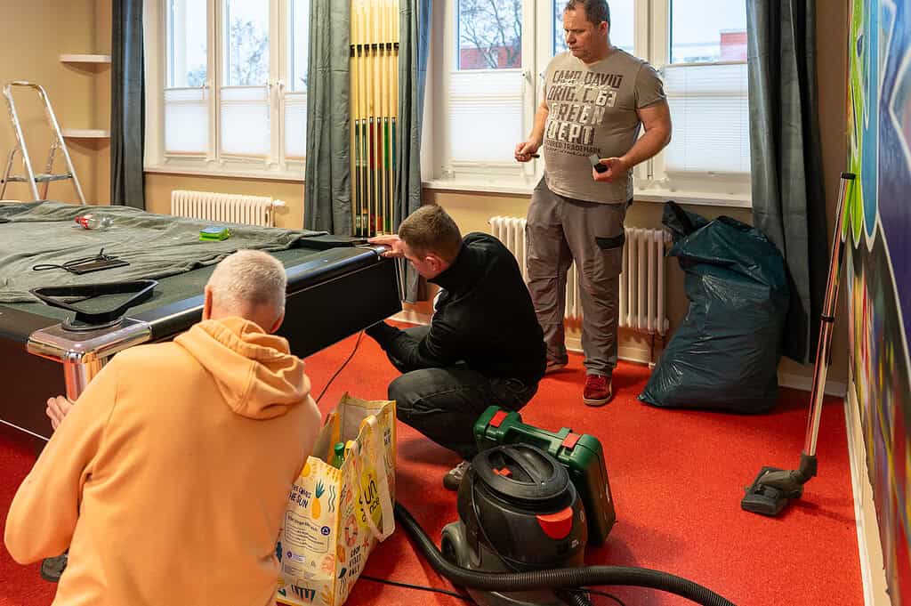 Jugendliche beim Umbau des Jugendzentrums in ein gemütliches Wohnzimmer.