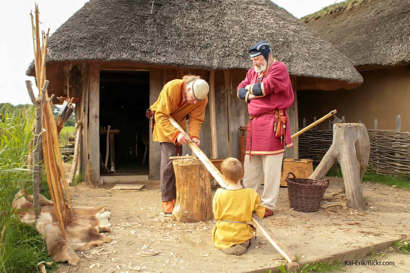 Nachbildung einer Steinzeit-Siedlung mit Menschen in historischen Kostümen.